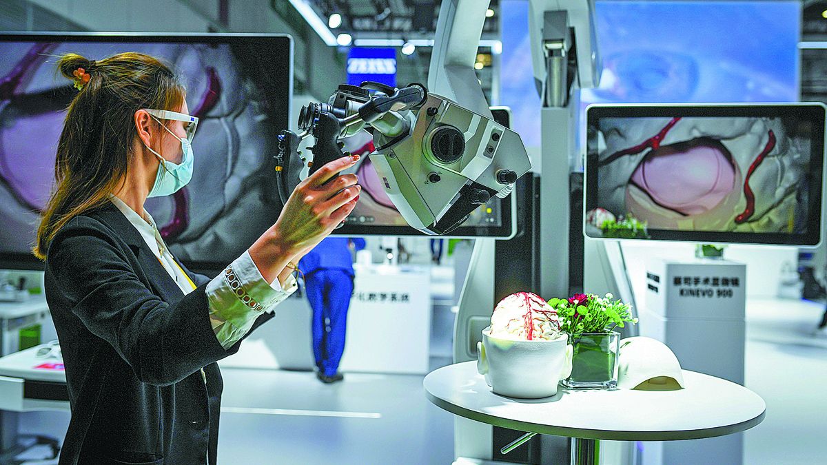 En un expositor en la tercera Exposición Internacional de Importaciones de China en Shanghai, una técnica muestra un microscopio para operaciones que utiliza tecnología de inteligencia artificial. LI RENZI / XINHUA