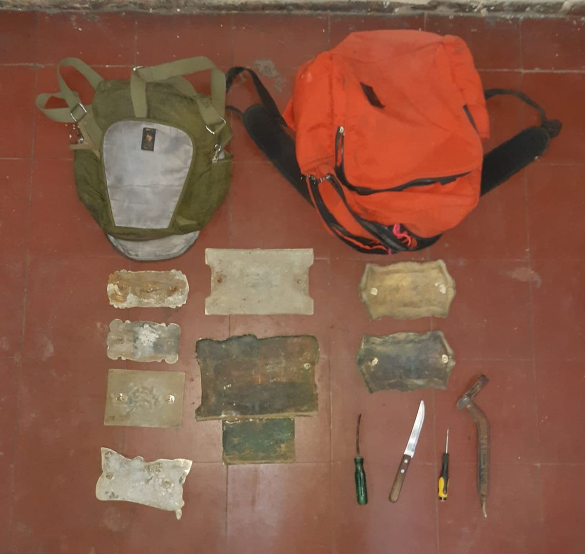 Ocho placas de bronce y una llave tipo ganzúa se encontraron en los bolsos de los delincuentes.