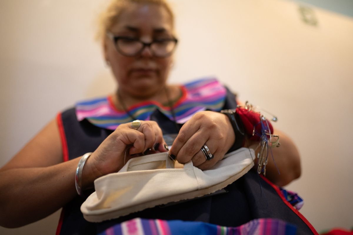 Una de las costureras de esta Fiesta de la Vendimia da los últimos puntos al elástico de las alpargatas de un bailarín. Una de las costureras de esta Fiesta de la Vendimia da los últimos puntos al elástico de las alpargatas de un bailarín.