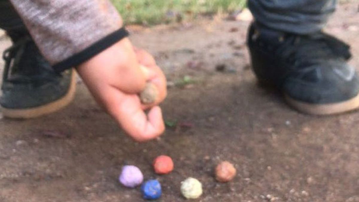 Juani juega con bolitas que él mismo fabricó con los frutos de un pino.
