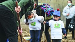 Niños y padres plantan árboles en Beijing el 22 de marzo. LI HE / XINHUA