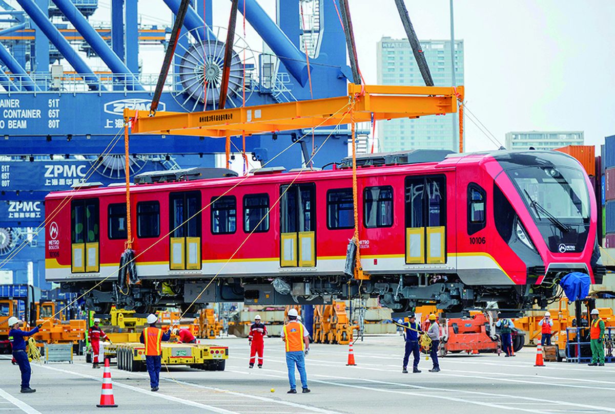 Trabajadores participan en la descarga de los primeros vagones del metro de Bogotá, enviados desde China, en una terminal portuaria de Cartagena, Colombia, el 2 de septiembre. MANUEL PEDRAZA / AFP.