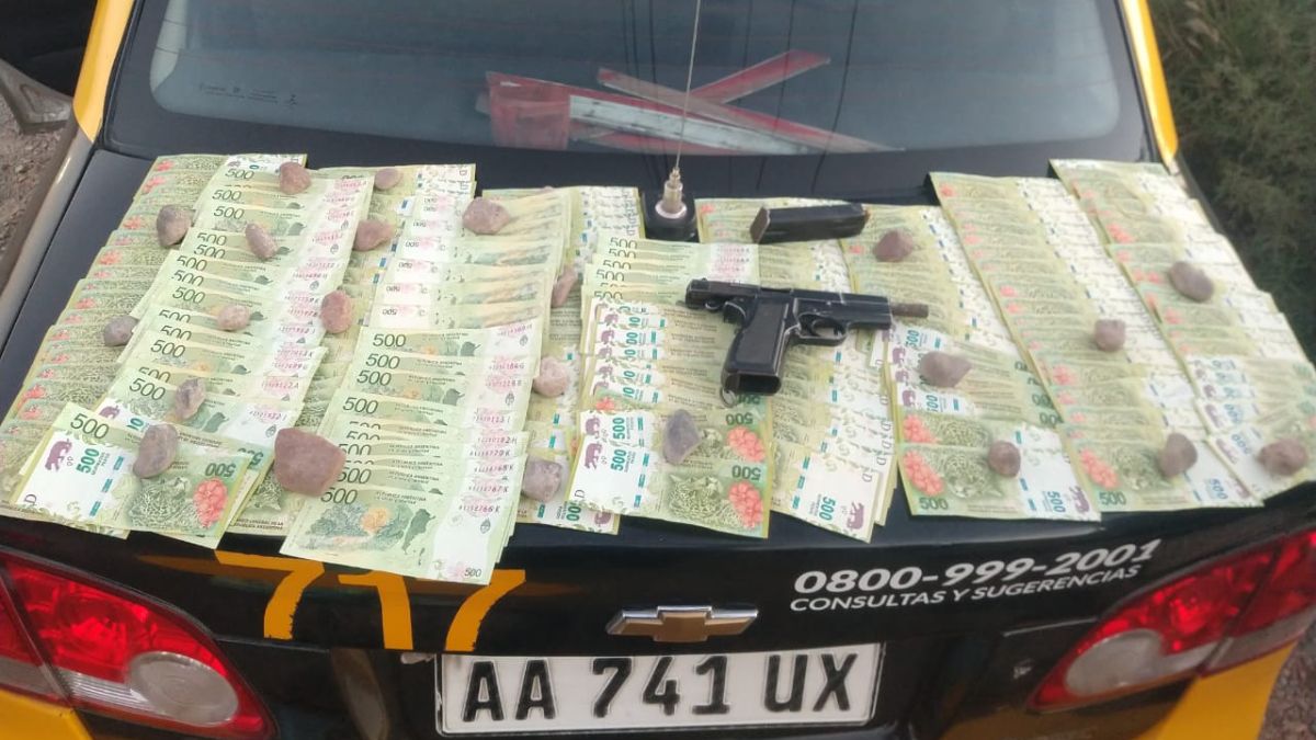Sobre el baúl del taxi que transportaba a un sospechoso se exhibió el dinero y la pistola encontrada entre las pertenencias del pasajero que quedó detenido en el Oeste de Godoy Cruz.