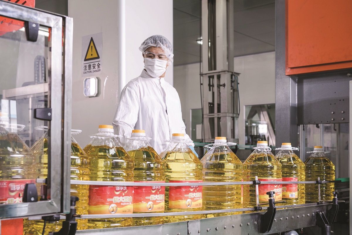 Un trabajador revisa productos en una planta de trituración de semillas oleaginosas de la compañía Louis Dreyfus en Zhangjiagang