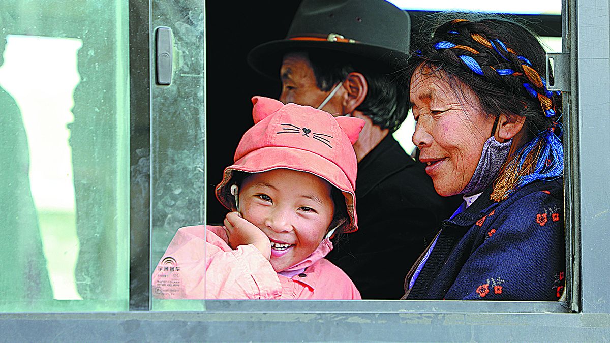 Unos residentes en un autobús de transbordo en el condado de Chonggyai en la ciudad de Lhokha