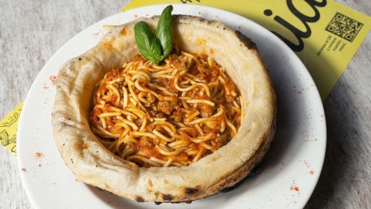 La pasta servida sobre pizza en este bodegón de Buenos Aires.