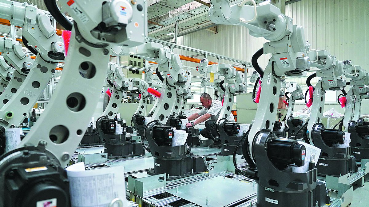 Un empleado revisa los robots soldadores en un fabricante en Tangshan, provincia de Hebei. MOU YU / XINHUA