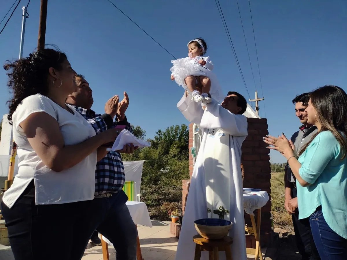 El sacerdote Leonardo Di Carlo con gente de la comunidad.