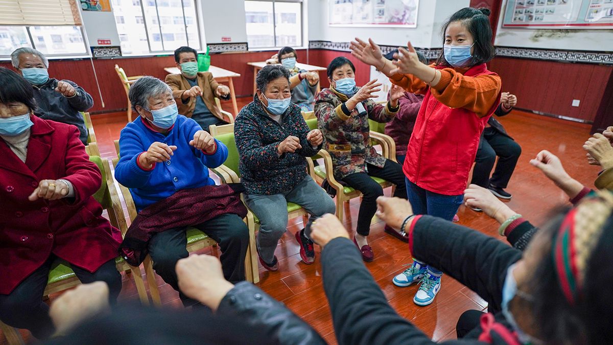 Las personas mayores ejercitan los dedos con una trabajadora en un centro de atención para la tercera edad en Yancheng
