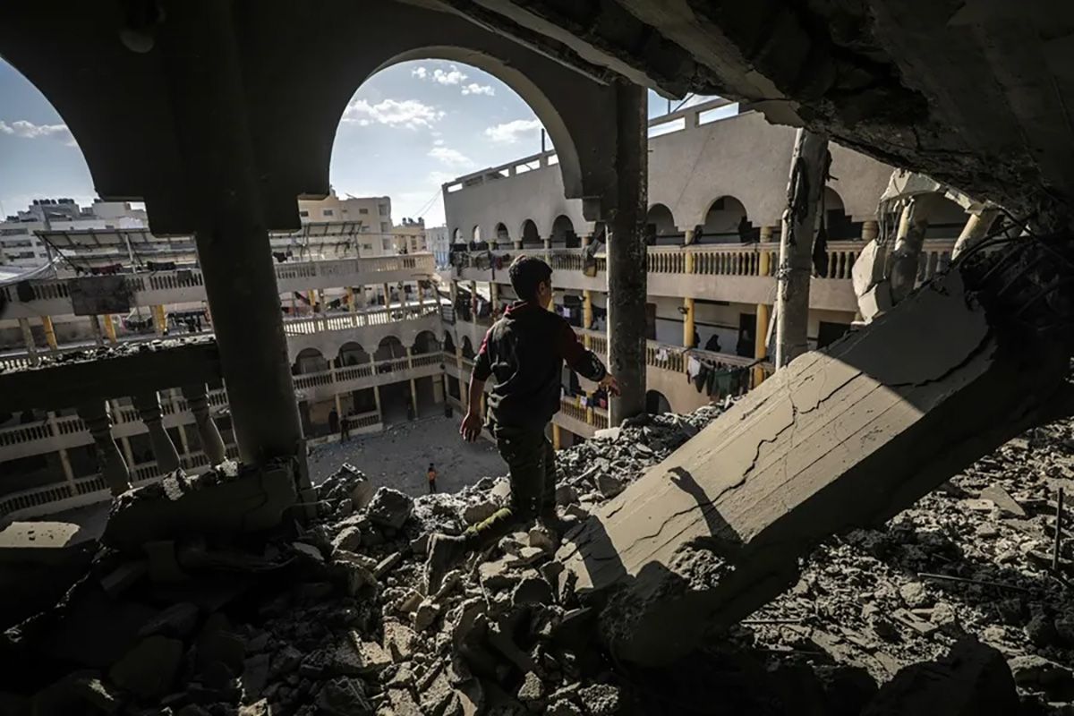Un niño palestino camino entre escombros en una escuela