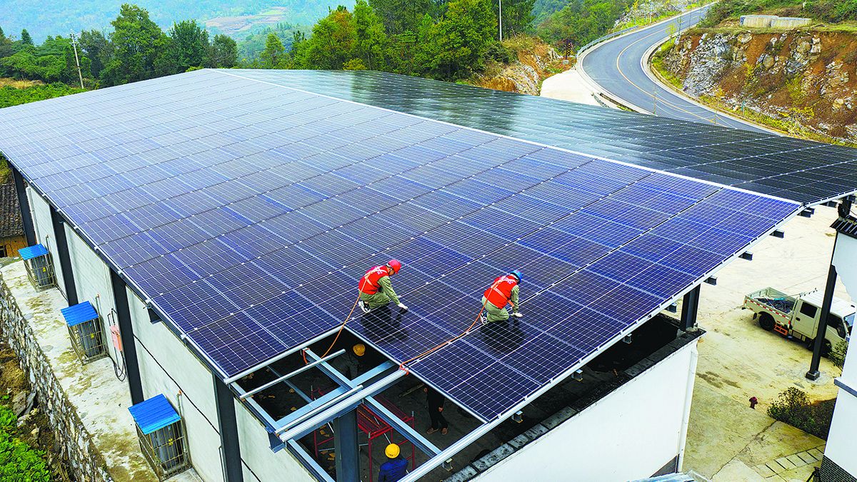 Unos trabajadores instalan paneles fotovoltaicos en un techo en Chuanxindian, una aldea en el condado de Zigui, provincia de Hubei, en octubre de 2021. MEI XUEFEI / PARA CHINA DAILY