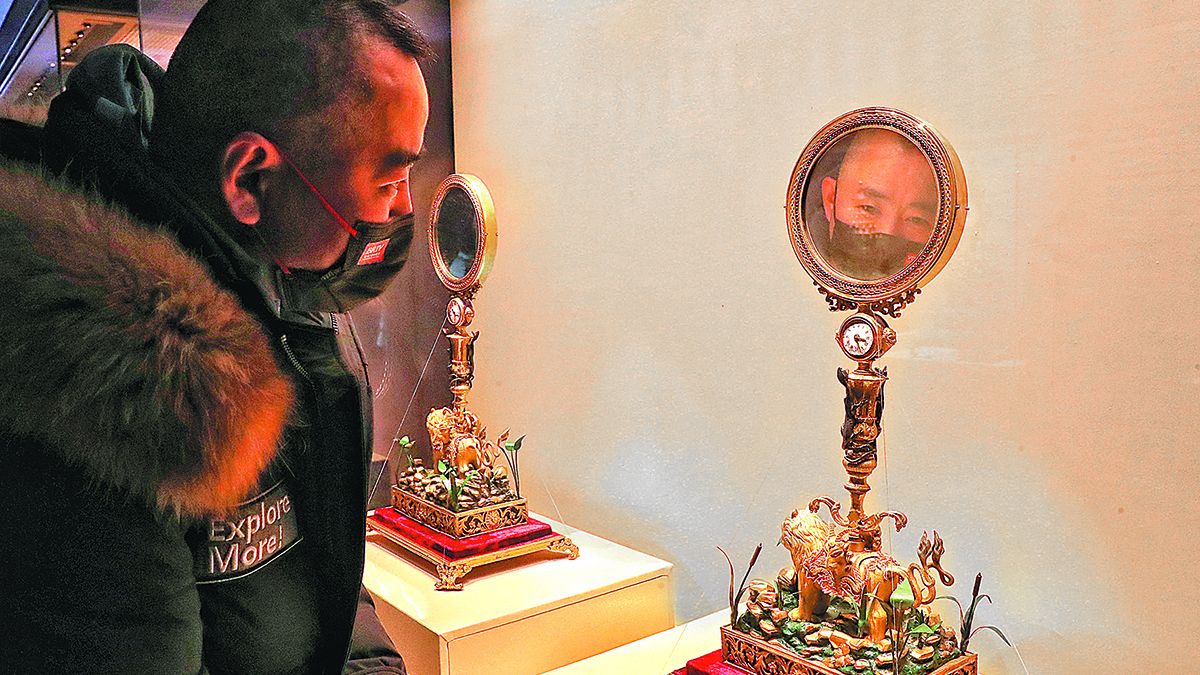Un visitante observa uno de los relojes adornados en la exposición del Museo del Palacio de Beijing. JIANG DONG / CHINA DAILY