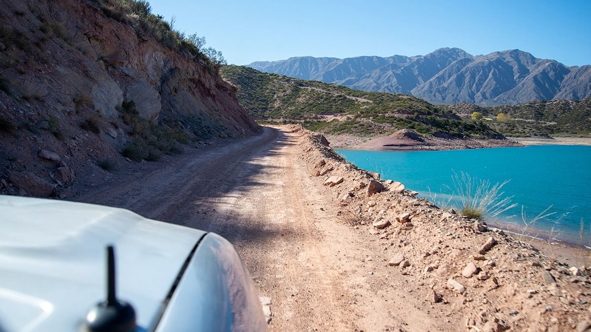 La senda se interna entre los cerros. El borde del lago es jurisdicción de la provincia hasta los 1200 metros de distancia.