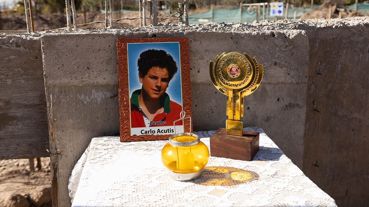 Una foto de Carlo Acutis y la escultura que contiene reliquias de primer grado del joven beato posan en medio del lugar donde se construye la iglesia en Mendoza. Una foto de Carlo Acutis y la escultura que contiene reliquias de primer grado del joven beato posan en medio del lugar donde se construye la iglesia en Mendoza.