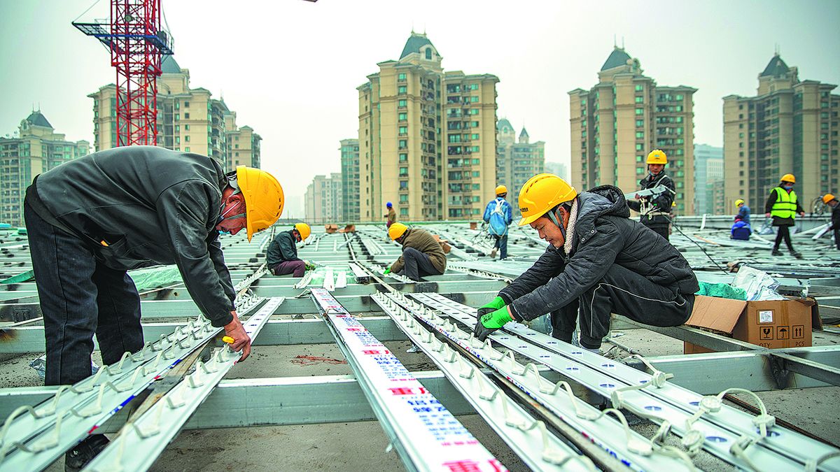 Unos trabajadores instalan luces decorativas para una base clave de producción de cine y televisión que se está construyendo en Chongqing el mes pasado. HUANG WEI / XINHUA 