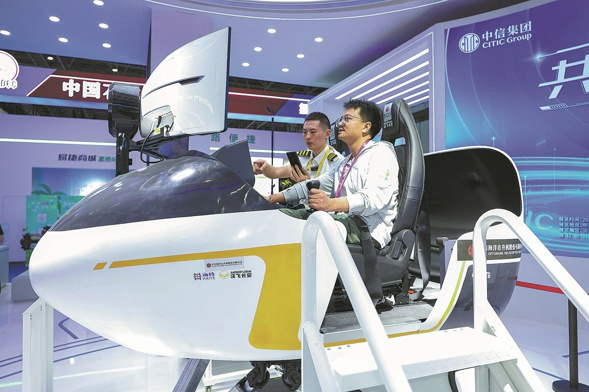 Un visitante (derecha) experimenta un simulador de helicóptero de CITIC Offshore Helicopter Co Ltd durante la Exposición Internacional de Productos de Consumo de China 2025 en Haikou, provincia de Hainan, en abril. LUO YUNFEI / SERVICIO DE NOTICIAS DE CHINA