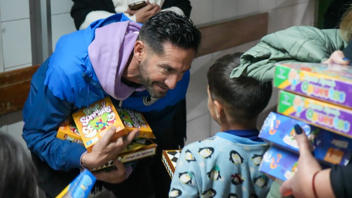 El arquero Maximiliano Gagliardo entregándole uno de los regalos a un chico que vino corriendo de la felicidad a recibirlos. El arquero Maximiliano Gagliardo entregándole uno de los regalos a un chico que vino corriendo de la felicidad a recibirlos.