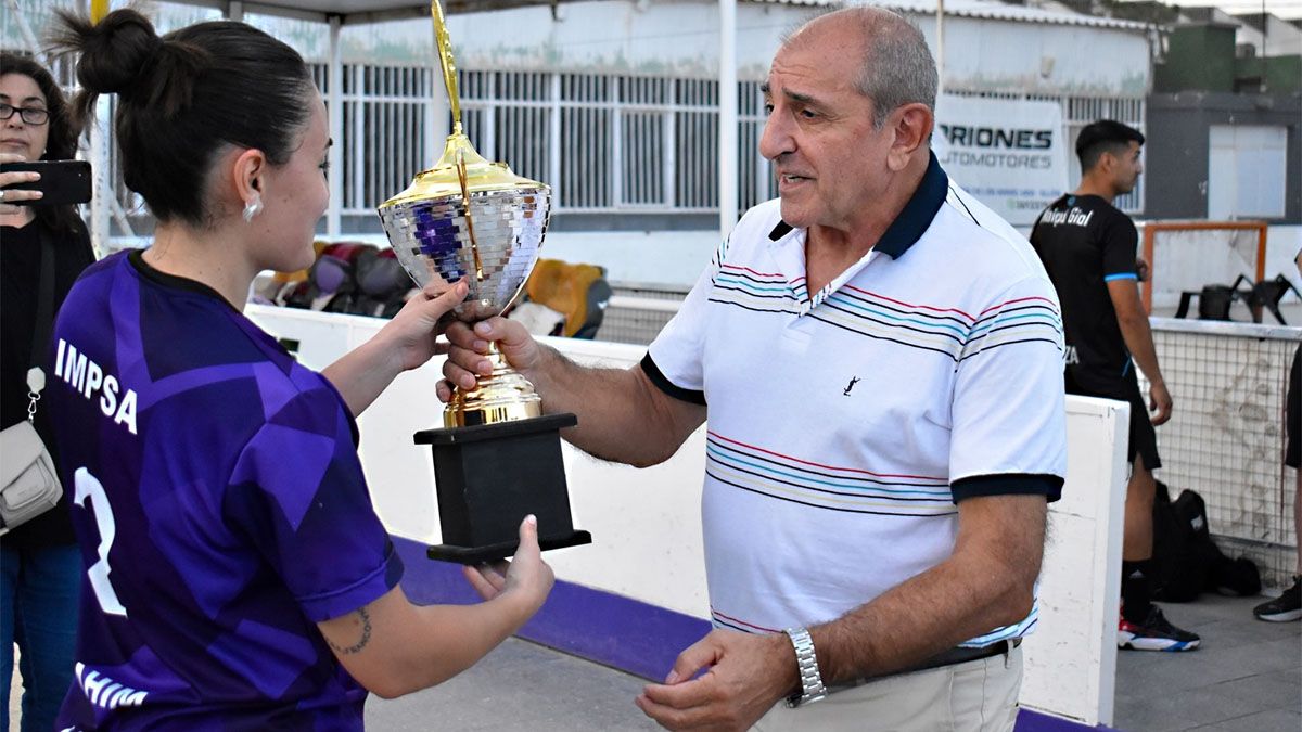Yamila Nahim, una de las referentes de IMPSA B, recibe la copa de manos del presidente de la AMP, Alberto Badui.