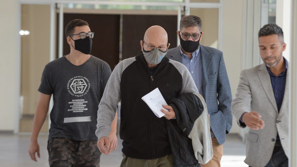 Luis Lobos llegando a la sala de audiencias es guiado por personal del Poder Judicial. A la izquierda, su hijo Facundo.