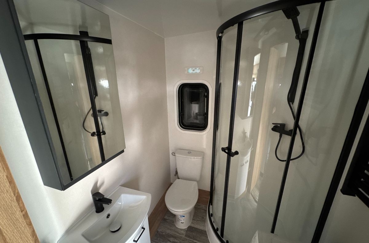 Entre las comodidades de la casa rodante se encuentra su espacioso baño con ducha. Entre las comodidades de la casa rodante se encuentra su espacioso baño con ducha.