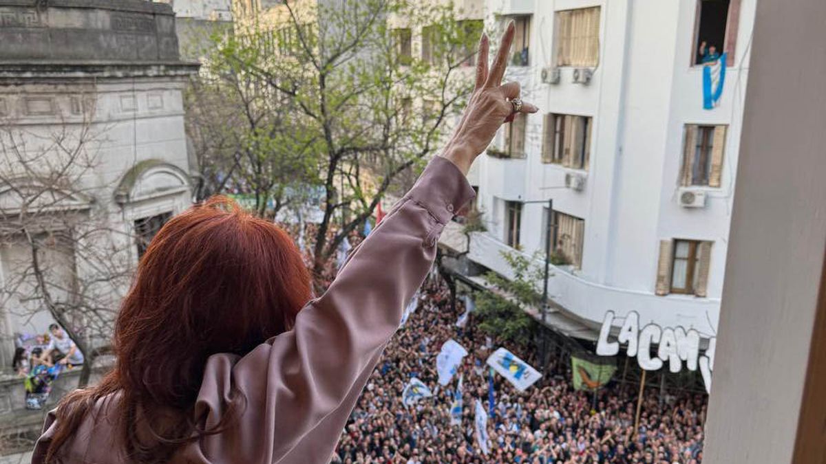 Con los dedos en V Cristina Kirchner saluda a sus seguidores.