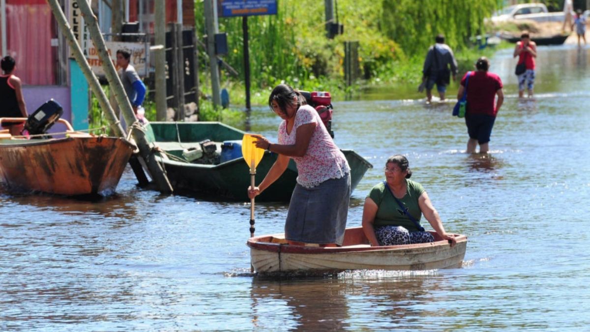 Habitantes reman en una calle inundada en Villa Paranacito