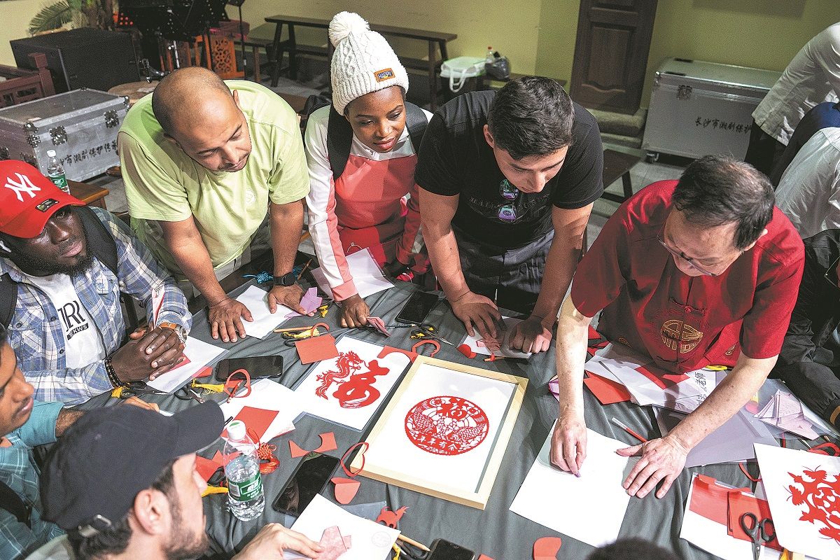 Los estudiantes internacionales aprenden el arte del papel recortado en el Museo del Patrimonio Cultural Inmaterial en Changsha, provincia de Hunan. CHEN SIHAN / XINHUA