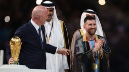 Messi recibe la Copa del Mundo de manos de Gianni Infantino con la túnica.
