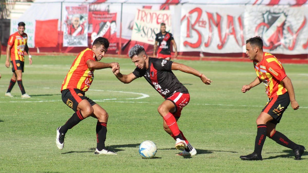Matías Persia, de Maipú, maniobra entre dos jugadores.