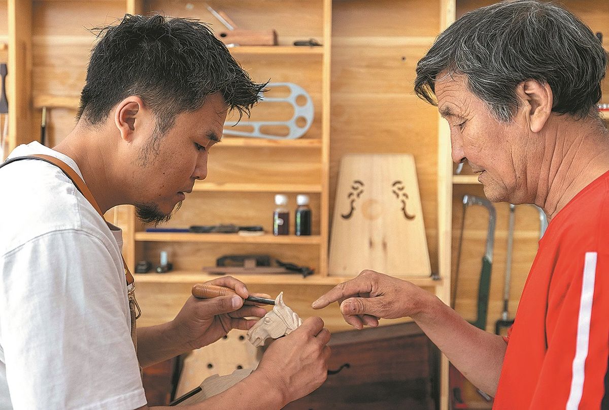 El maestro artesano Ulji (derecha) transmite a su hijo Tulguur el oficio tradicional familiar de fabricar morin khuur. DING GENHOU / PARA CHINA DAILY El maestro artesano Ulji (derecha) transmite a su hijo Tulguur el oficio tradicional familiar de fabricar morin khuur. DING GENHOU / PARA CHINA DAILY