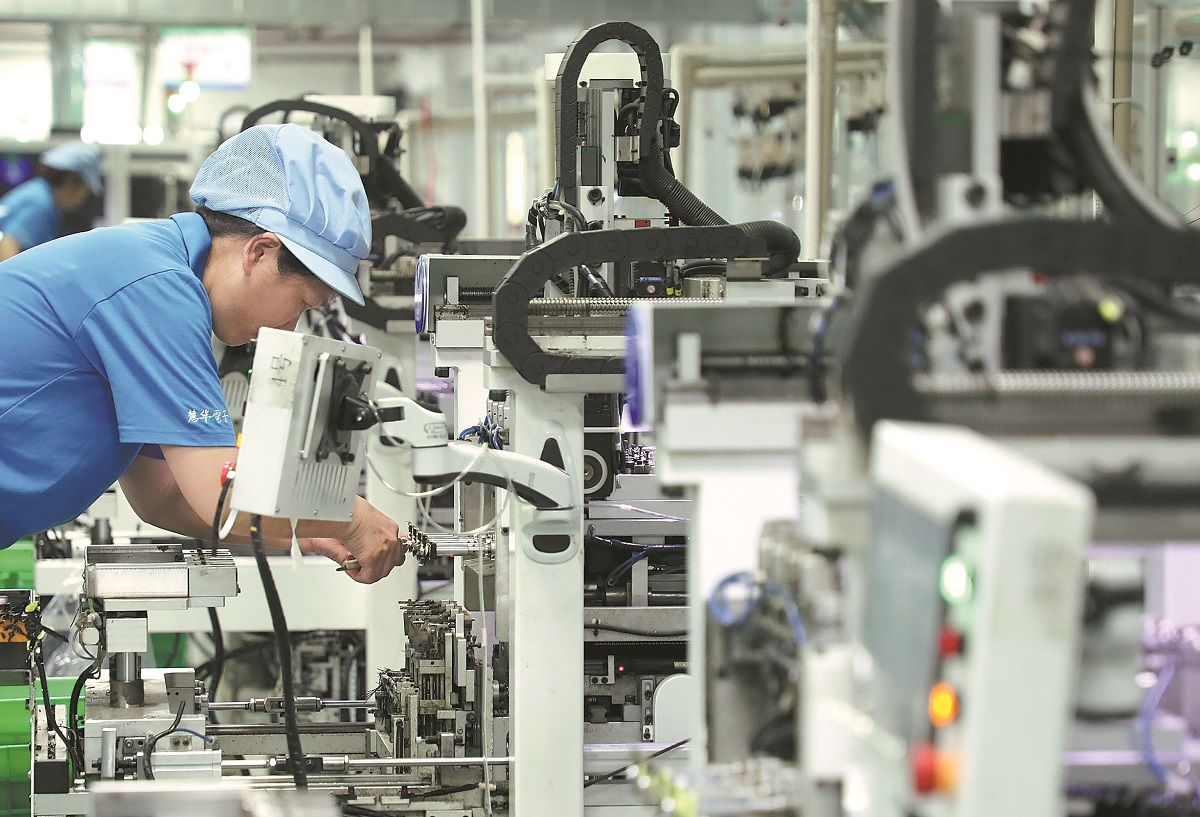 Empleadas trabajan en la línea de producción de una empresa de artículos electrónicos en Zixing, provincia de Hunan.LI KE / PARA CHINA DAILY