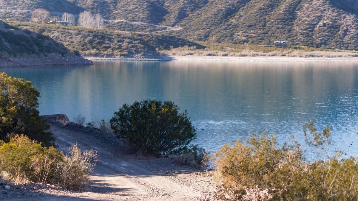 La vista del dique Potrerillos durante el camino de la costa norte. Las montañas abrazando el cambio de colores del agua y el reflejo de los rayos del sol. La vista del dique Potrerillos durante el camino de la costa norte. Las montañas abrazando el cambio de colores del agua y el reflejo de los rayos del sol.