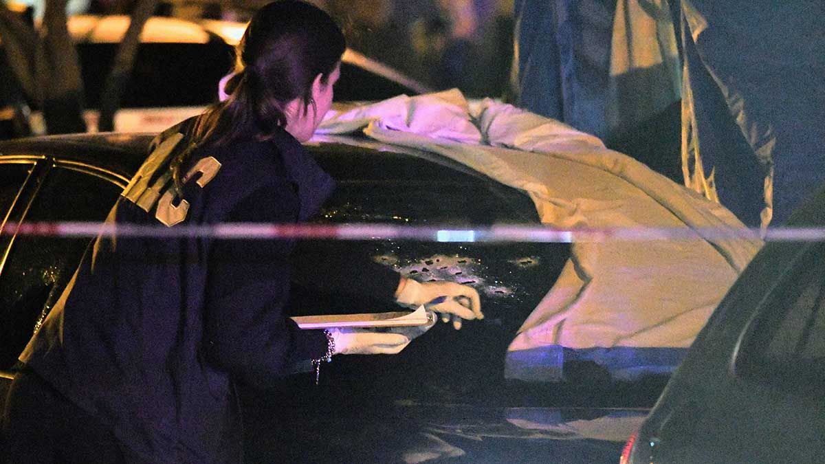 La policía científica trabaja sobre el automóvil donde fueron asesinado un joven y su pequeño hijo