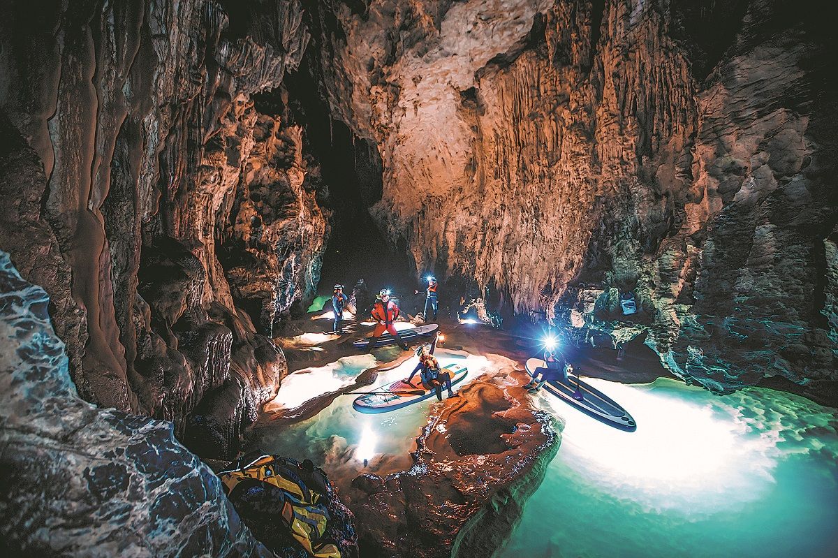 Turistas exploran la cueva de Shilong, en la ciudad de Qingzhen, provincia de Guizhou, en tabla de paddleboard. PARA USO DE CHINA DAILY