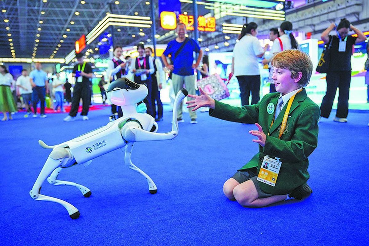 Un estudiante internacional interactúa con un perro robótico durante la exposición. WANG CHENGLONG / PARA CHINA DAILY. Un estudiante internacional interactúa con un perro robótico durante la exposición. WANG CHENGLONG / PARA CHINA DAILY.