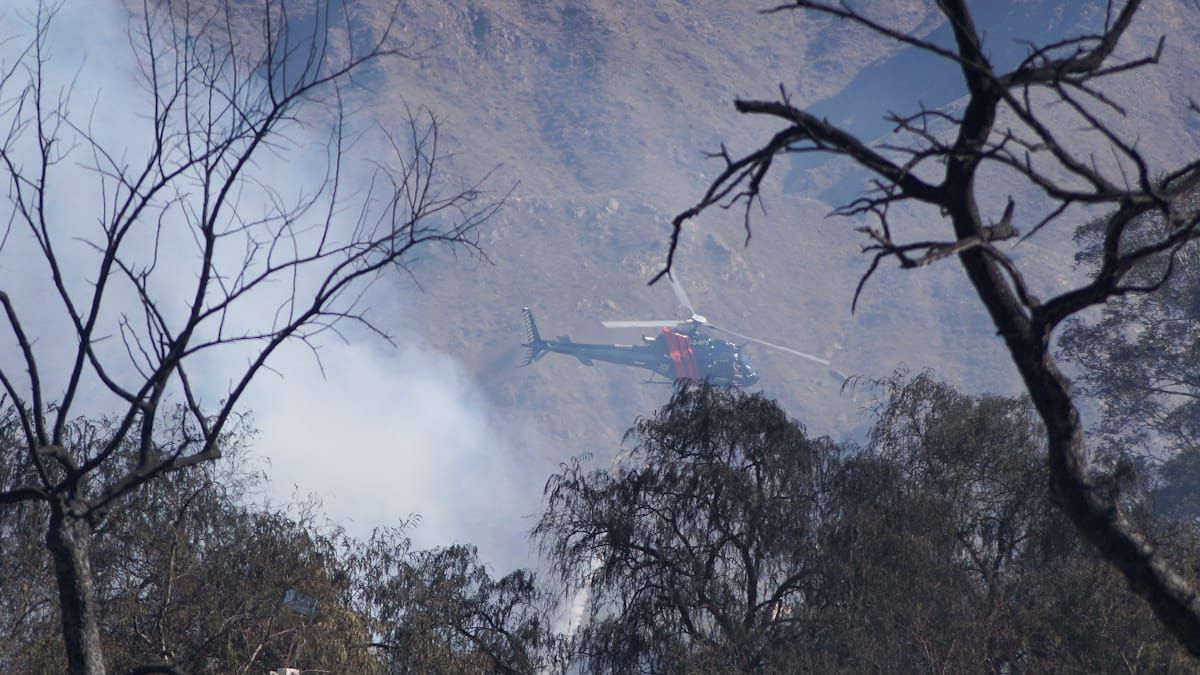 El helicóptero de la policía sobrevuela la zona, rociando agua para enfriar el lugar. El helicóptero de la policía sobrevuela la zona, rociando agua para enfriar el lugar.