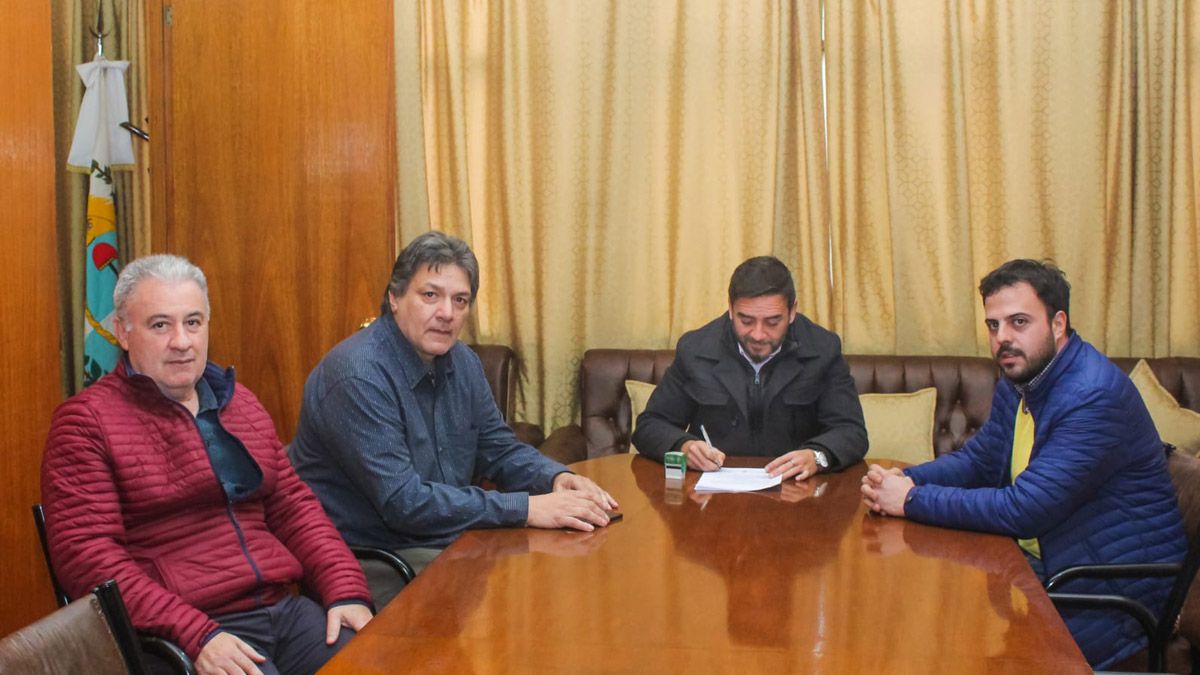 Momento en que Fernando Ubieta firma la resolución para el adelanto de un incremento del 17% para los municipales de La Paz. El intendente está aquí con otros funcionarios y con el representante de los trabajadores.