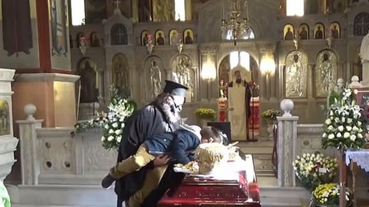 La imagen del sacerdote que obligó al niño a besar el atúd.