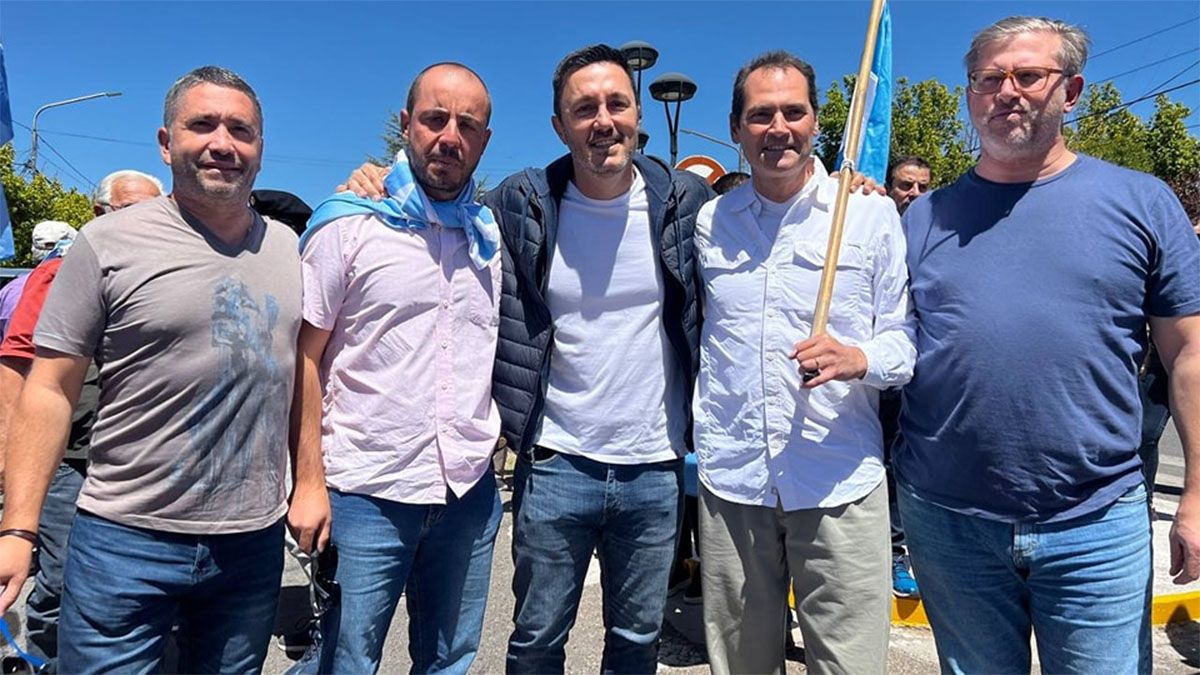 Mauricio Badaloni, con la bandera en una de sus manos, se abraza con Luis Petri en la marcha en reclamo del reconocimiento de Nación a mapuches en Mendoza.