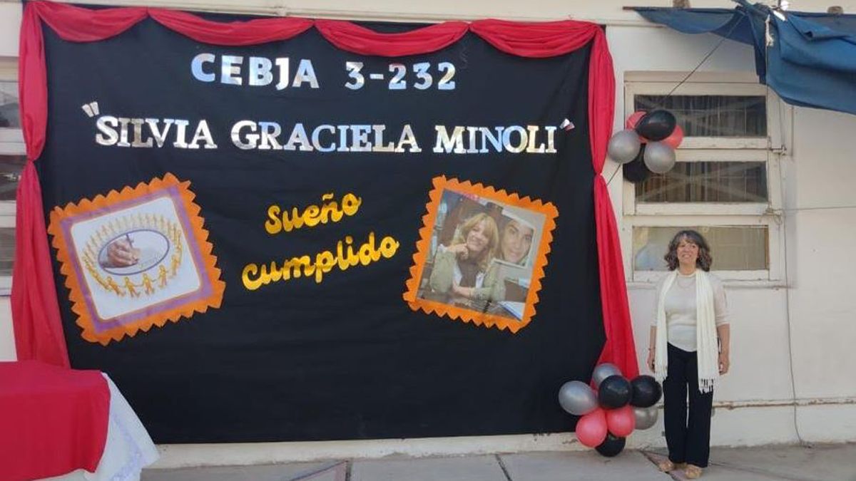 Emocionada, Silvia Minoli junto al cartel que indica que su nombre es el que se eligió para un centro educativo. No podía faltar allí la imagen de Johana Chacón.