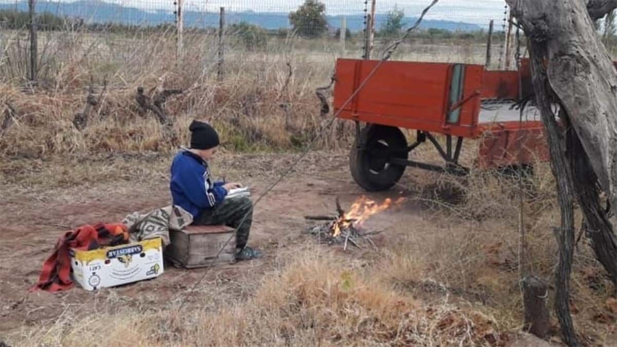 La foto del esfuerzo: con frío y en medio de una finca, no deja de estudiar