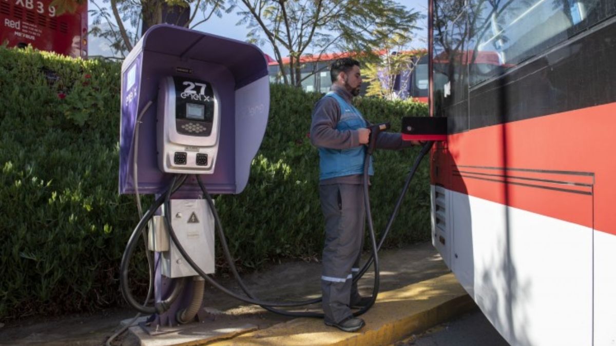 Una persona cargando un autobús eléctrico en Chile. Los buses eléctricos tienen una huella de carbono baja y, a largo plazo, podrían ser una opción más barata que los vehículos diésel (Imagen: Tamara Merino / IMF, CC BY-NC-ND) Una persona cargando un autobús eléctrico en Chile. Los buses eléctricos tienen una huella de carbono baja y, a largo plazo, podrían ser una opción más barata que los vehículos diésel (Imagen: Tamara Merino / IMF, CC BY-NC-ND)