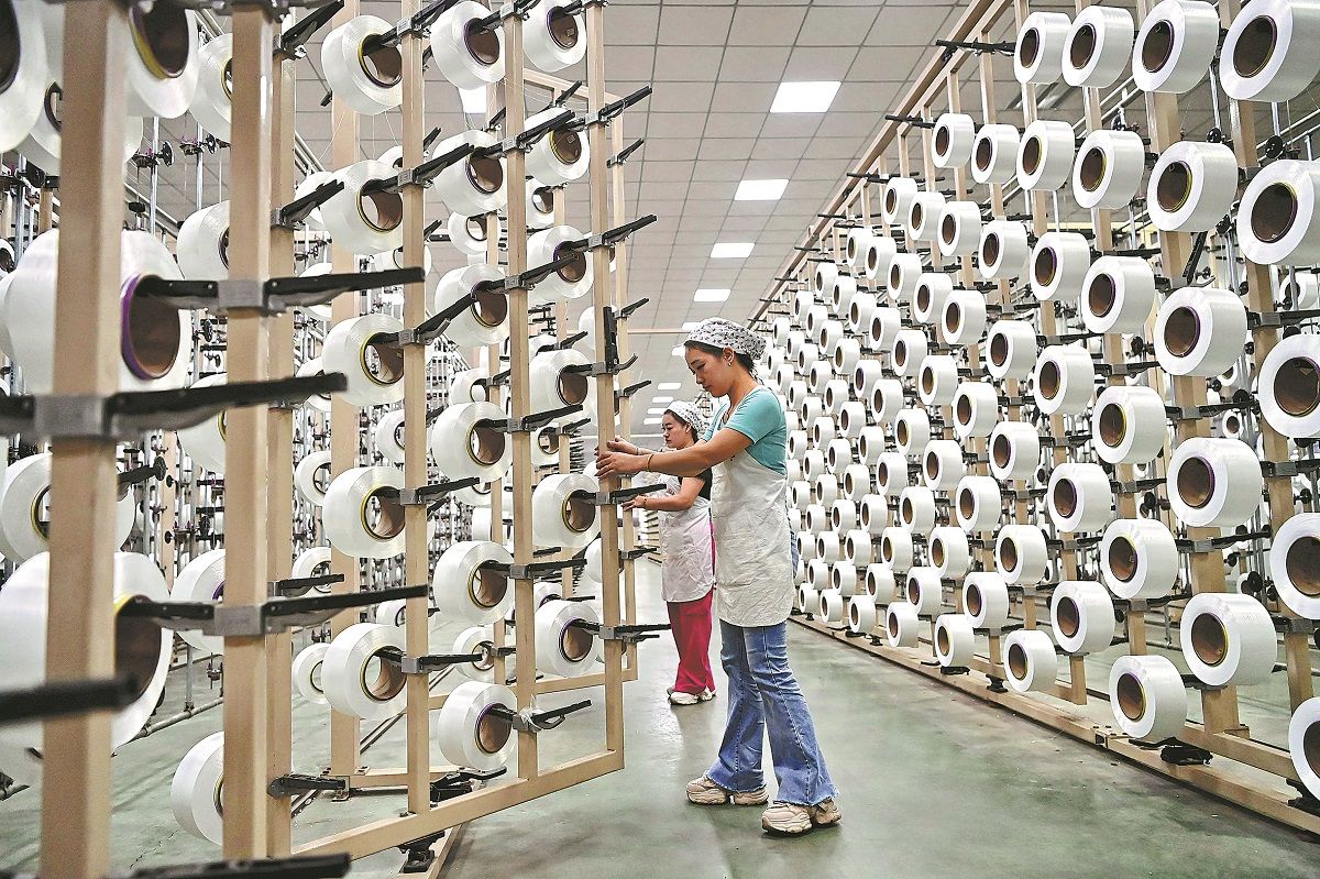 Dos empleadas trabajan en la línea de producción de una empresa textil en Ganzhou, provincia de Jiangxi. ZHU HAIPENG / PARA CHINA DAILY
