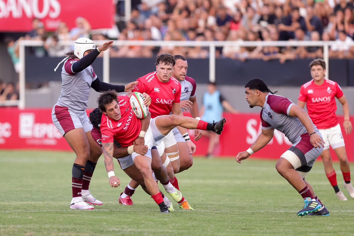 Julián Hernández, autor de 17 puntos para Dogos XV, es tackleado con el apoyo de Aitor Bildosola en el debut en el Súper Rugby Américas. Julián Hernández, autor de 17 puntos para Dogos XV, es tackleado con el apoyo de Aitor Bildosola en el debut en el Súper Rugby Américas.
