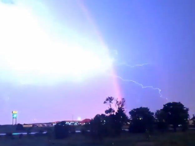 Un arcoíris y un rayo chocan en el cielo