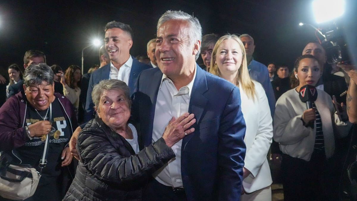 Una vecina contenta saluda efusivamente al gobernador Alfredo Cornejo.