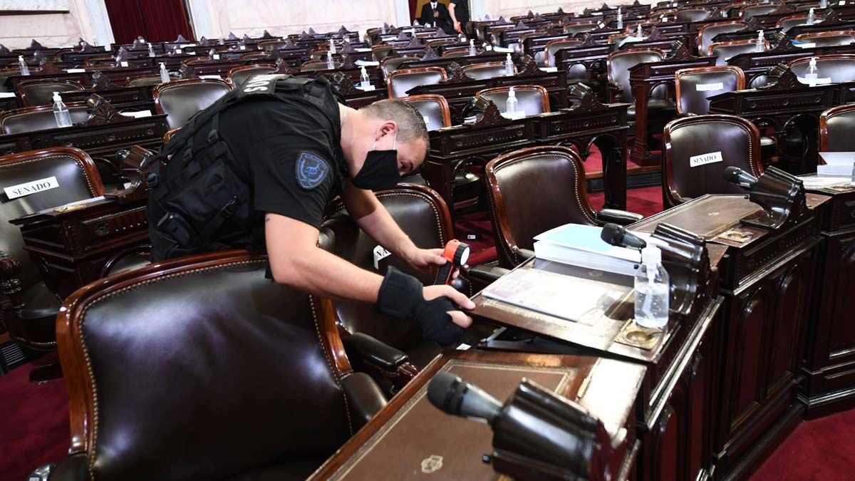 Seguridad. Un policía observa minuciosamente las bancas.