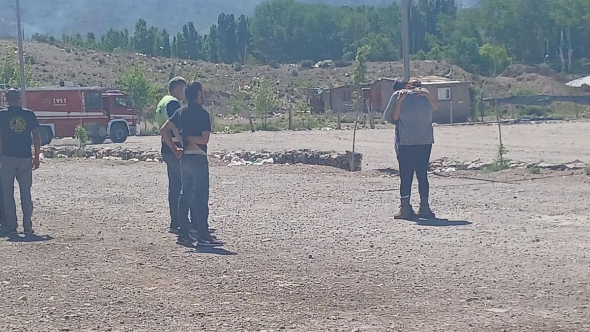 En la imagen Edgardo Rodríguez se ve de espaldas con una remera gris abrazado a un familiar. Fue rescatado del cerro Montura