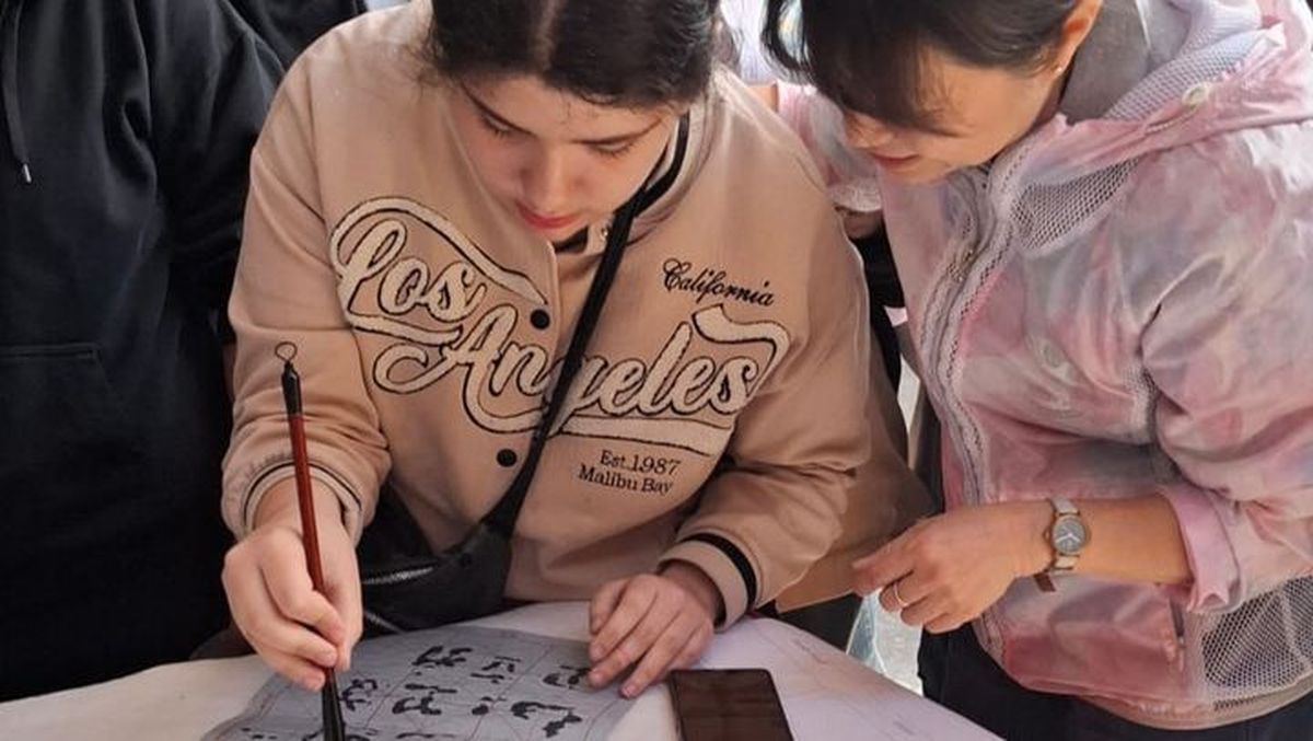 Una alumna dibuja las grafías del idioma chino mandarín con la instrucción de una maestra del Instituto Confucio, de la Universidad de Congreso. Una alumna dibuja las grafías del idioma chino mandarín con la instrucción de una maestra del Instituto Confucio, de la Universidad de Congreso.