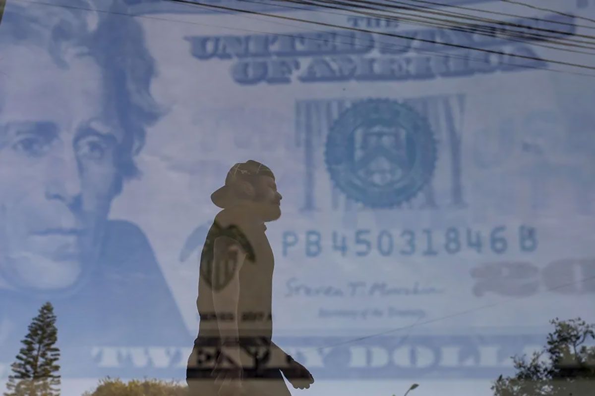 &nbsp;La nueva ley fiscal destinará millones de dólares a controles migratorios. Un hombre caminando frente a una casa de cambio (Fotocomposición archivo). Crédito: EFE/ Francisco Guasco.